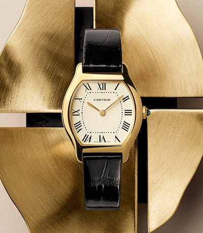 Image of Cartier Tortue on metal background. Tap to shop Cartier watches image