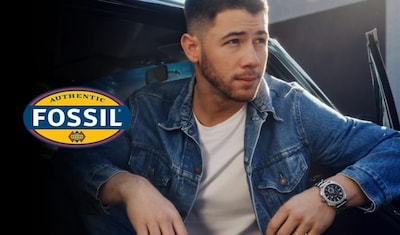 Fossil Watch logo, a stylish man in a denim jacket leans against a car, showcasing a Fossil watch with a sleek black dial and orange accents. image