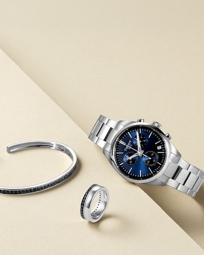 Image of mens jewellery and Tissot watch on cream background. Fathers Day - make his day golden with a gift he'll treasure. Tap to shop fathers day gifts image