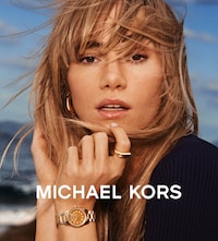 Image of a woman wearing Michael Kors jewellery with Michael Kors logo displayed at the bottom image