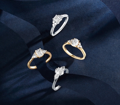 Mappin & Webb Traceable diamond engagement rings on blue background. Tap to shop image