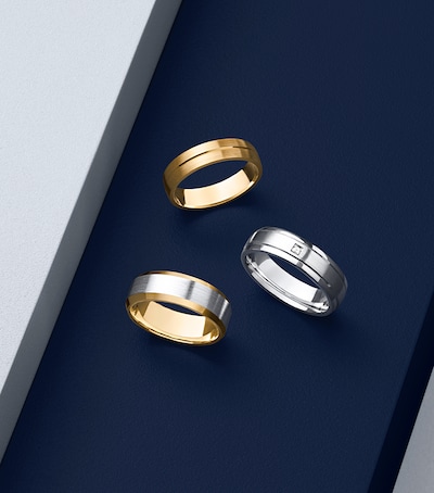 Men's wedding rings stacked on white step image