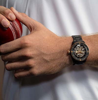 Image of man's hand holding cricket ball with Rado watch on the wrist. image