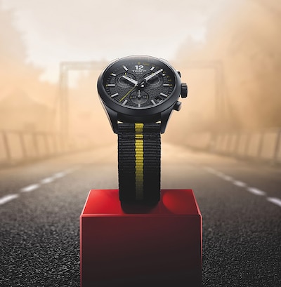 Tissot Tour De France watch on red podium. Tap to shop the watch image