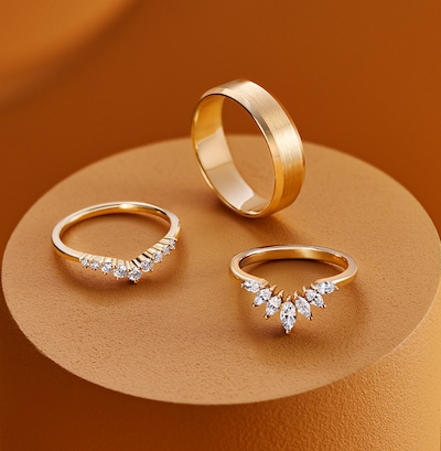 Goldsmiths bespoke wedding rings on orange podium background image