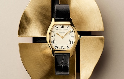 Black Strap Cartier Tortue watch on Gold metal background. New Watches & Wonders launch 2026. Tap to shop Cartier image